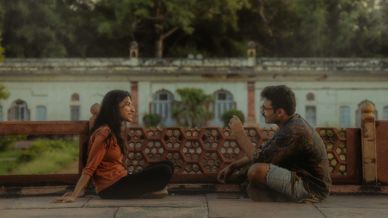A young couple sitting on a terrace, talking openly