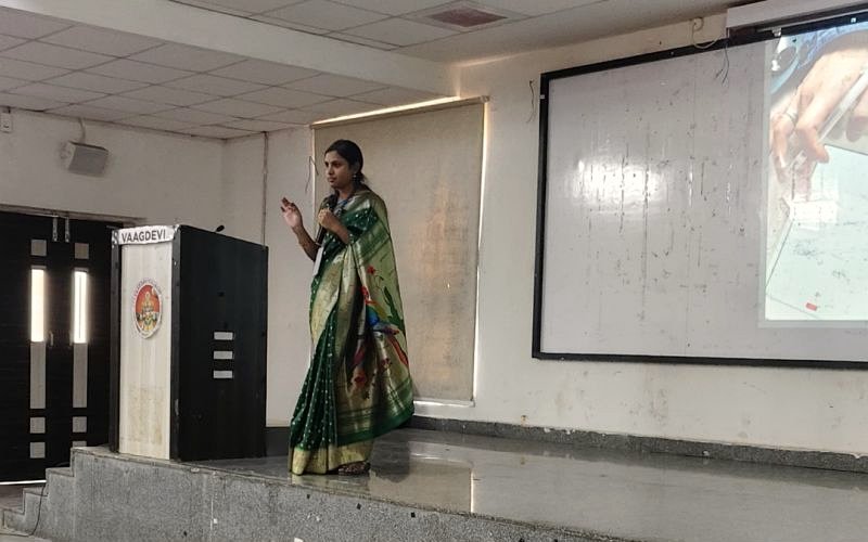 An InnerWhispers facilitator speaking to students on stage at Vaagdevi College