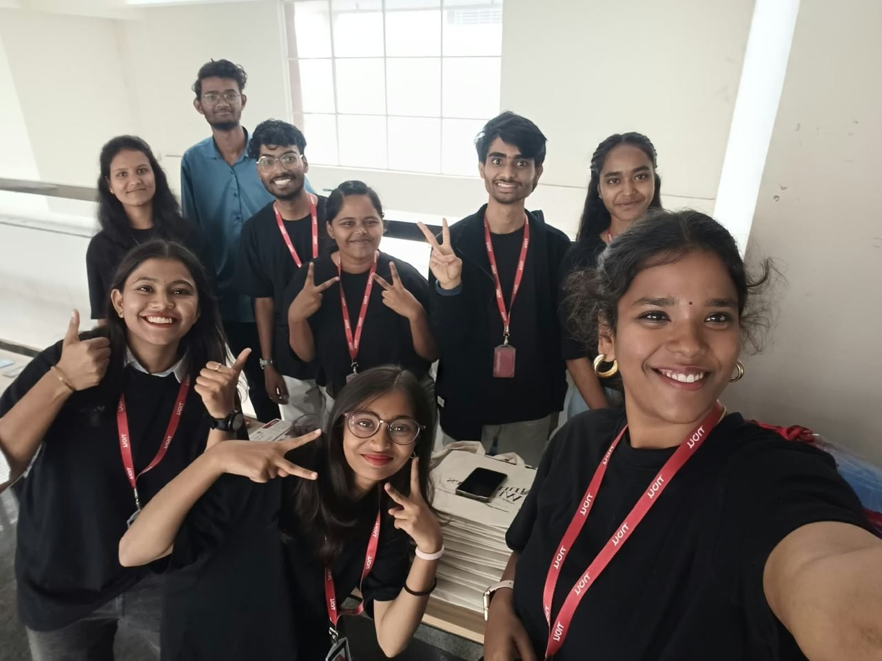 The InnerWhispers and NAU team in black T-shirts and NAU lanyards, smiling together in a group selfie at MENTIS