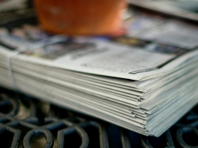 A neat stack of newspapers on a table