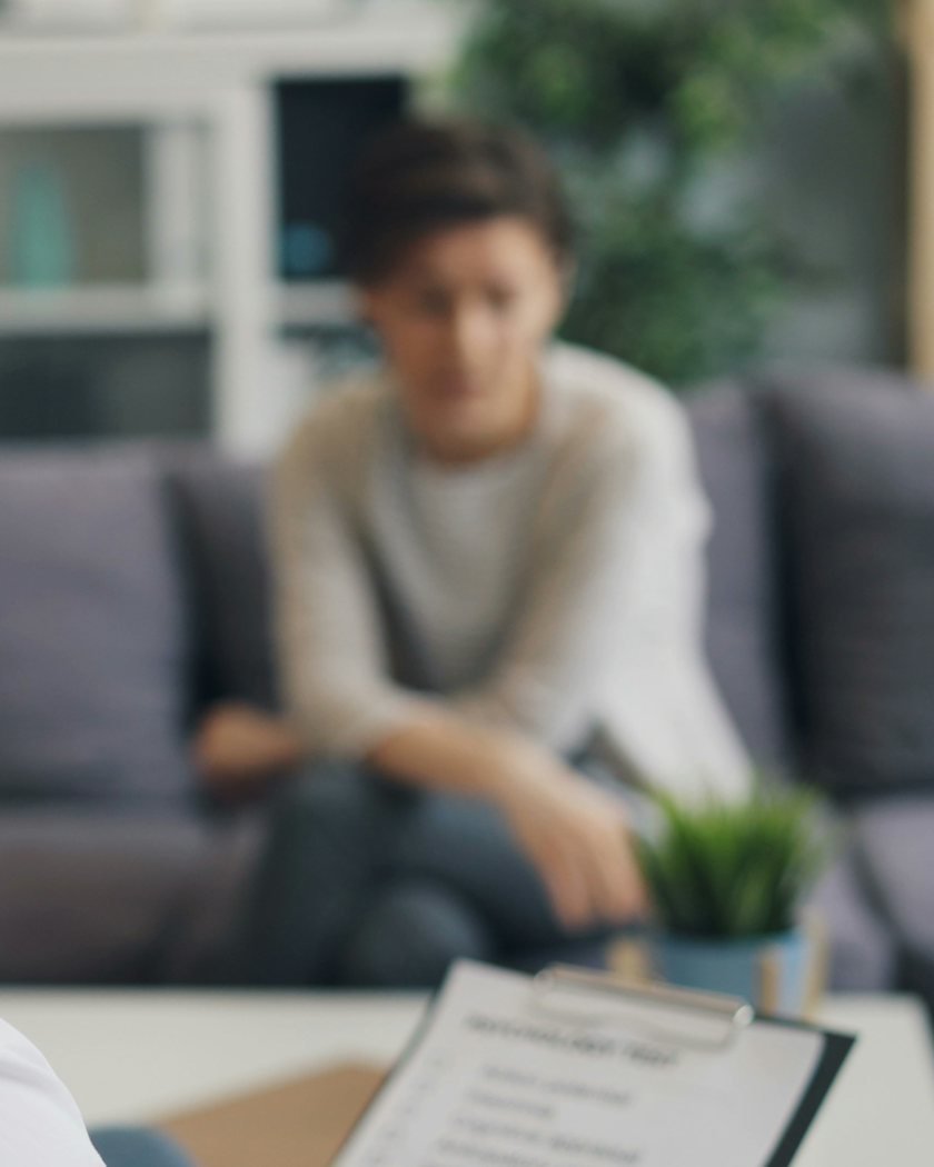 A counsellor with a clipboard listening to a client