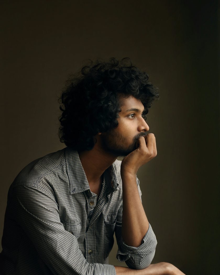 A man sitting quietly, reflecting with his hand on his chin