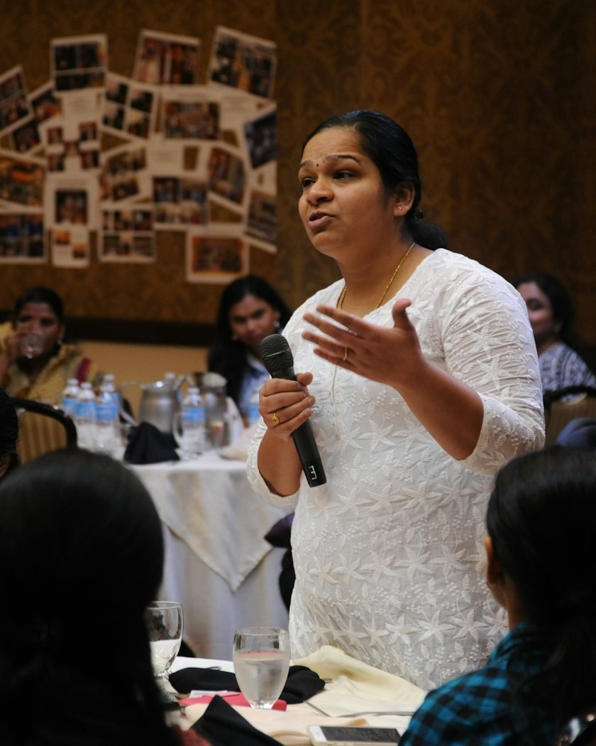 A facilitator speaking with a group of students during a workshop