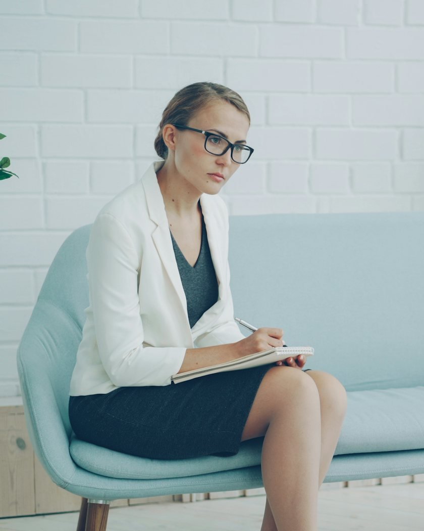 A professional taking notes while listening to a young woman