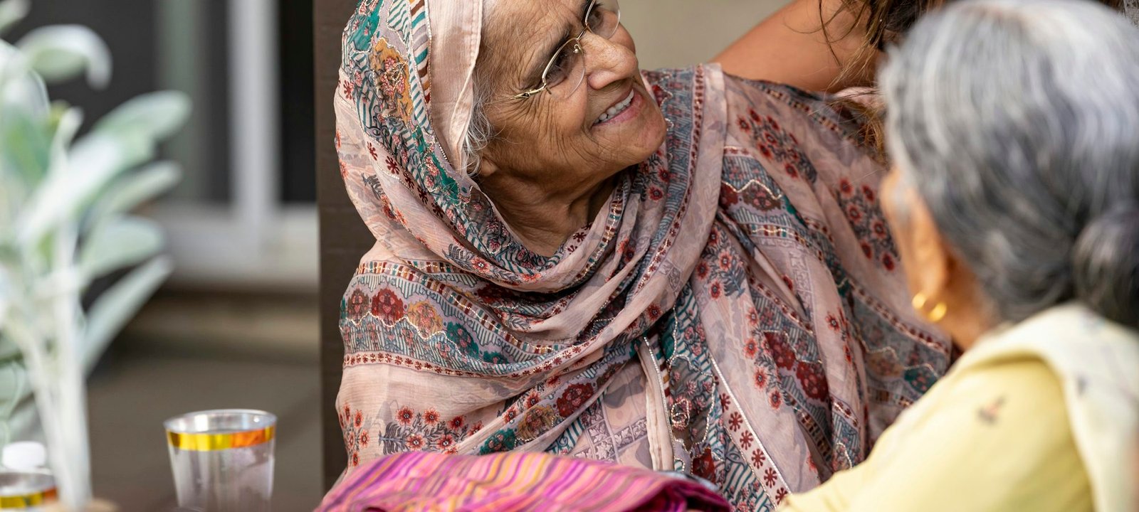 An older woman smiling warmly at the women of her family